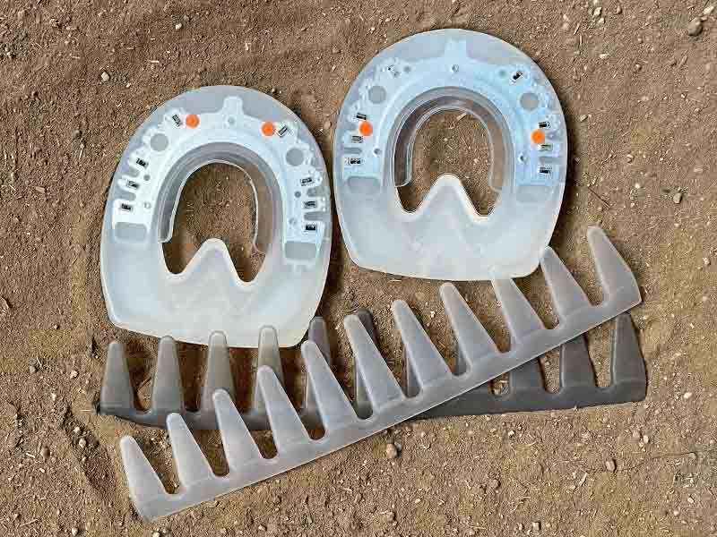 The urethane shoes for glued application and glue-on collars are placed in the sand of the riding arena.