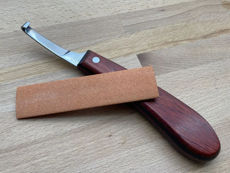 Hoof knife with sharpening stone – ideal whetstone for farriers and equine care.