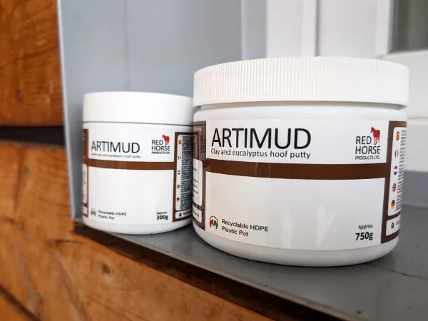 The two different package sizes of Artimud® – 750g and 300g – are placed on a windowsill.