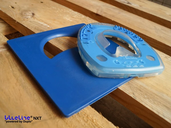 Der blueline® NXT Hufbeschlag liegt auf dem ebenfalls blauen, quadratischen Sole Relief Pad. Das Pad hat im oberen Bereich einen halbmondförmigen Ausschnitt.