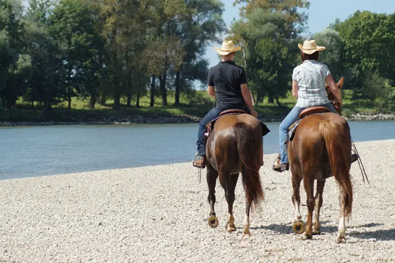 Two riders on gravel beside the Danube.