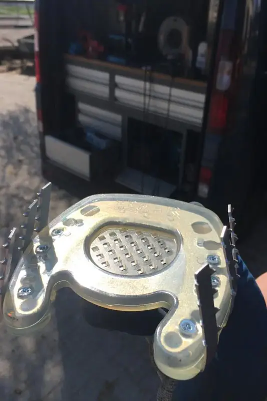 Ein zehenoffener Beschlag mit angeschraubten Cast-Haken vor dem Hufschmiedeauto.