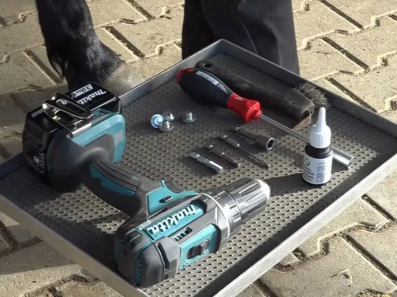 auf einem kleinen Arbeitstisch liegen ein Akkuschrauber von Makita, Schraubensicherung von Reidl, Pferdestollen und diverse Biteinsätze für die Montage der Pferdestollen