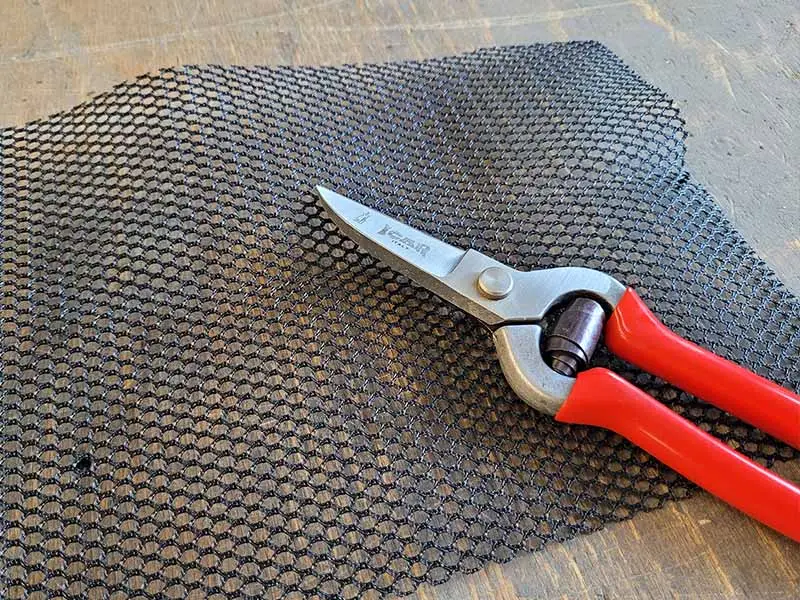 The glue-u mesh roll is placed on a workbench alongside the ICAR leather scissors.