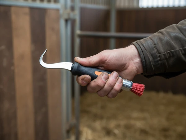 Ein Hufschmied hält den Hufauskratzer von Fifpe / Triple M in der Hand.