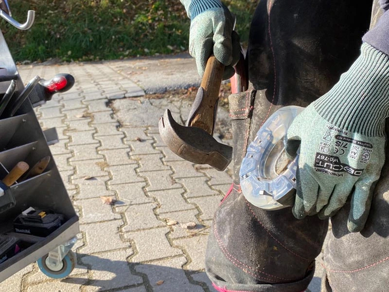 Farrier nailing a horseshoe onto a hoof using a Dick driving hammer with a hickory handle