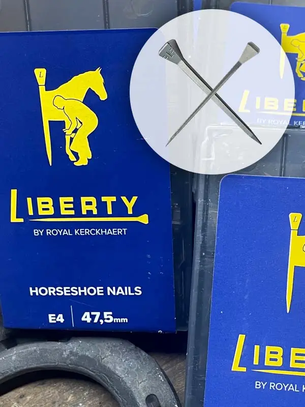 Imagebild für die Hufnägel von Liberty mit einem E-Nagelkopf; man sieht die Nägel und die blauen Verpackungen, außerdem einen Ausschnitt eines Hufeisens