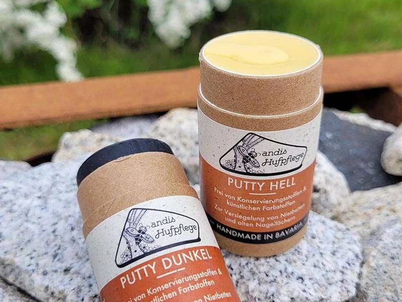 Putty Role hell und dunkel liegen auf Steinen, das dunkle ist ein Stück aus der Role herausgedrückt