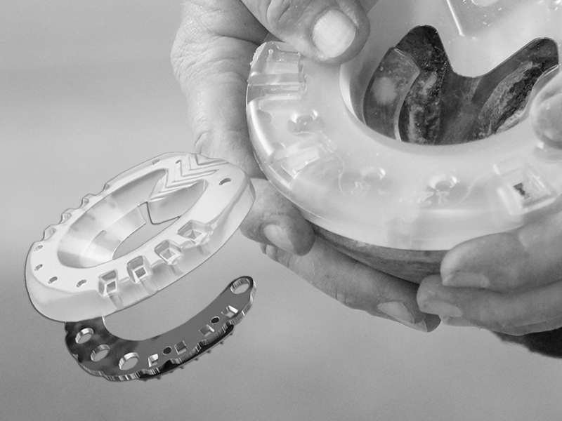 The farrier checks the fit of the composite horseshoe on the horse's hoof. A diagram illustrates the structure of the composite horseshoe. You can see the metal core and the plastic cover.