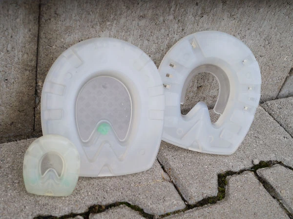 stoßdämpfende Kunststoffbeschläge für Pferde in drei verschiedenen Ausführungen stehen nebeneinander.