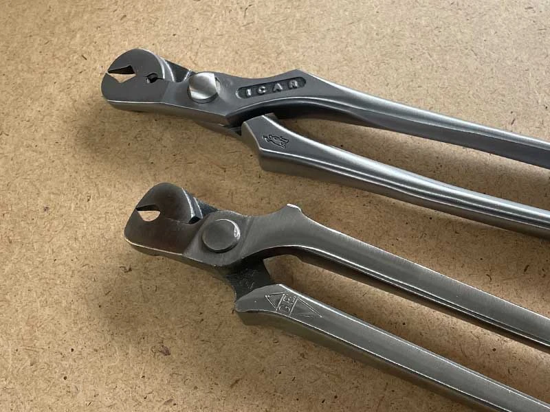 Two nail puller models by ICAR and GE lying on a workbench.