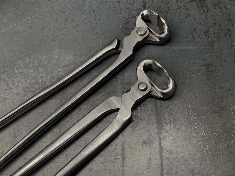 Dos modelos de tenazas de corte GE sobre una superficie metálica.