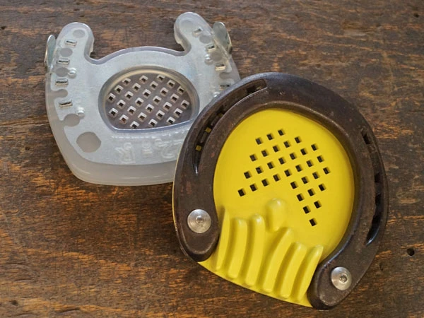 Immagine di una ferratura alternativa per la laminite con punta aperta e suola a griglia, accanto a un ferro tradizionale con una soletta a griglia.