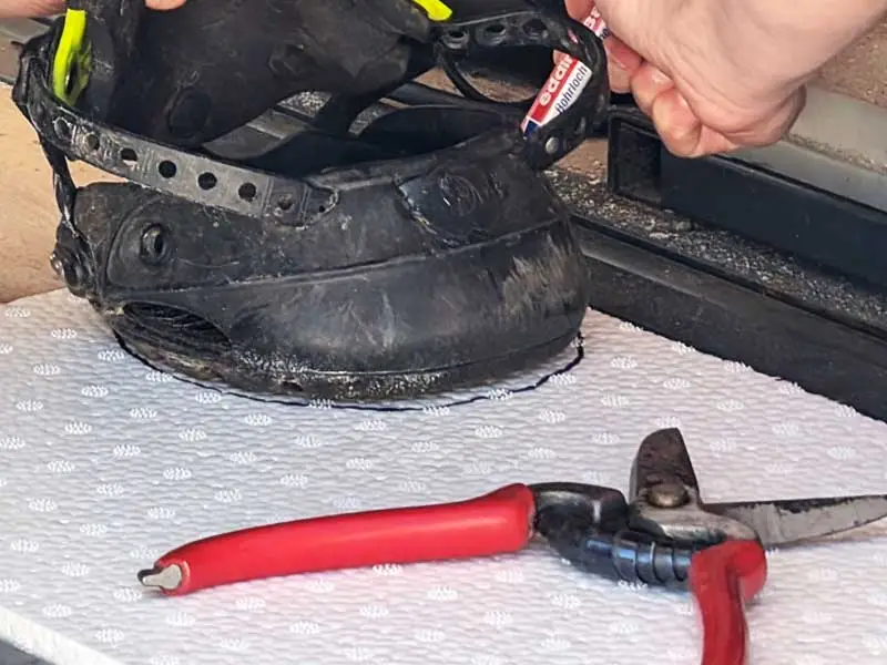Su una piastra ammortizzante bianca è posizionata una scarpetta. Il maniscalco traccia la forma dello stivale sulla piastra. Accanto ci sono le forbici ICAR per ritagliare la soletta.