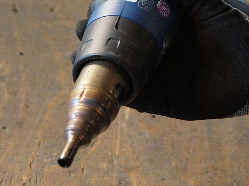 Hufschmied hält eine Steinel Heißluftpistole mit montierter Reduzierdüse in der Hand