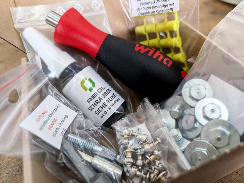 The individual components of the grip set in an open box.