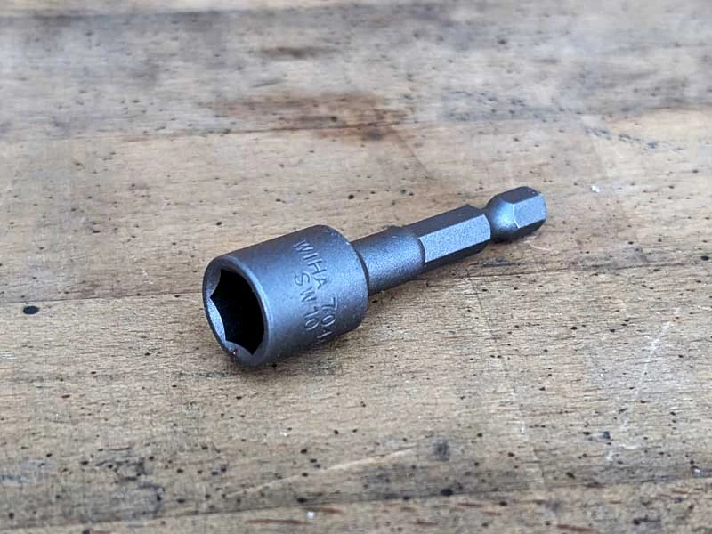 A stud wrench bit insert resting on a workbench.