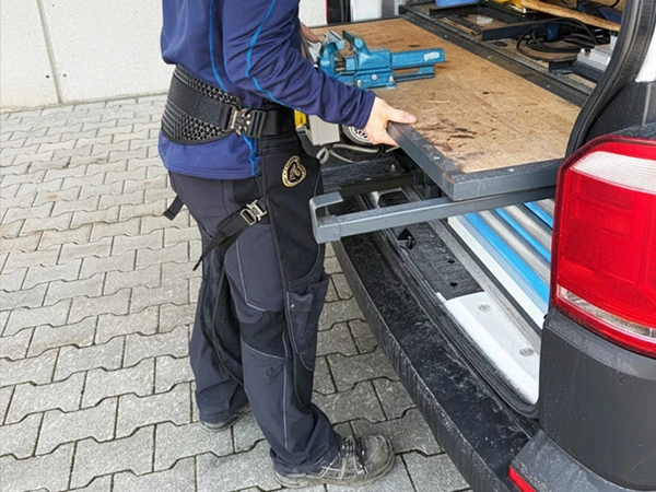 Un herrador lleva el delantal Silverback Original Pro junto a su carro de herraje.