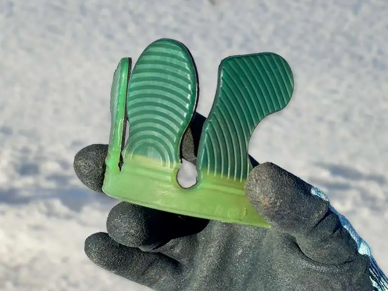 Detailaufnahme einer weicheren, grünlichen und flexibleren Klebelasche für einen Klebebeschlag im Winter - im Hintergrund ist Schnee