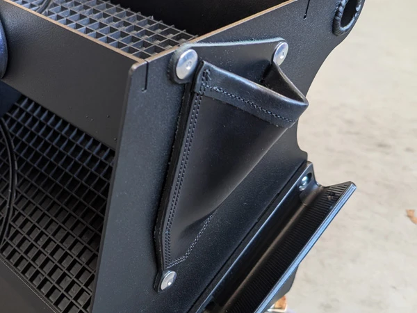 Eine seitliche Ledertasche bietet Paltz zur sicherern Aufbewahrung von Hufmessern.